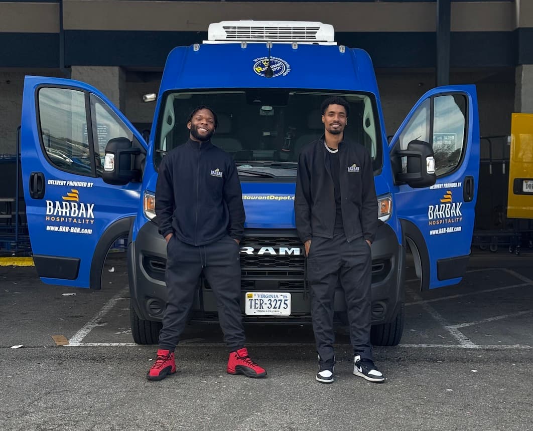 Two BarBak drivers standing in front of an open branded delivery van